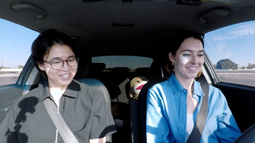 Yuji and a student smiling in the car on a sunny afternoon
